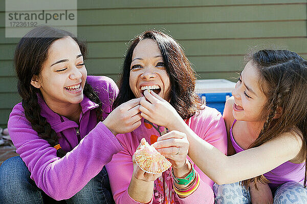 Zwei Schwestern füttern Mutter Cupcake