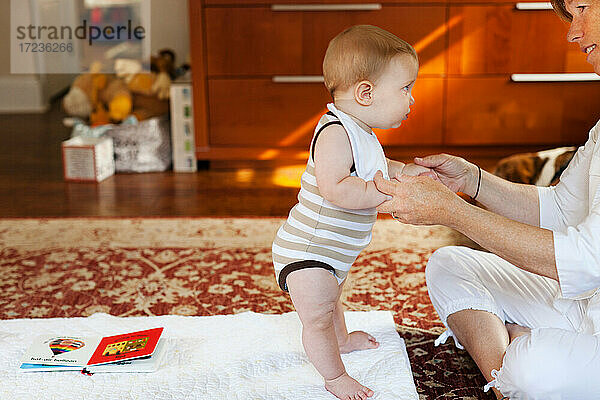 Mutter und Baby Sohn spielen auf Teppich