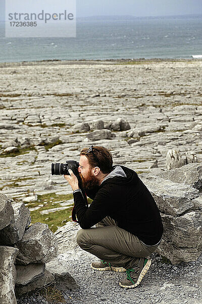 Mann beim Fotografieren  The Burren  County Clare  Irland