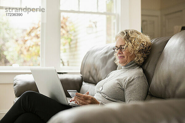 Seniorin beim Online-Einkauf am Laptop