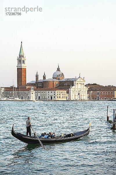 Gondoliere rudert in venezianischer Gondel auf dem Meer  Blick auf Kirche San Giorgio Maggiore  Venedig  Venetien  Italien  Europa