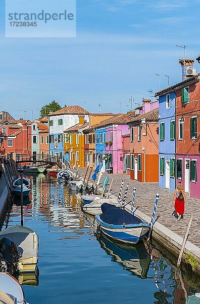 Junge Frau vor bunten Häusern  Kanal mit Booten und farbenprächtigen Häuserfassaden  Insel Burano  Venedig  Venetien  Italien  Europa