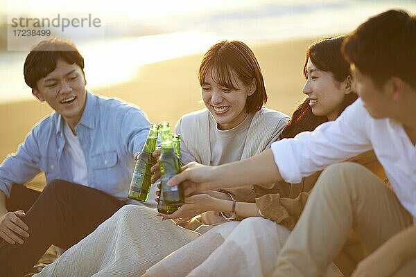 Junge japanische Freunde am Strand