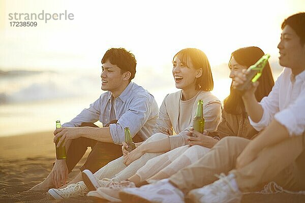 Junge japanische Freunde am Strand