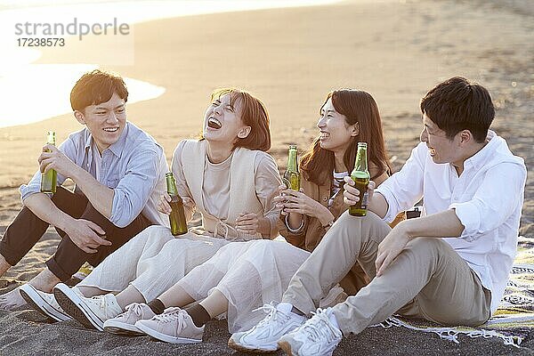 Junge japanische Freunde am Strand