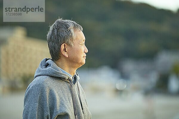 Älterer japanischer Mann am Strand