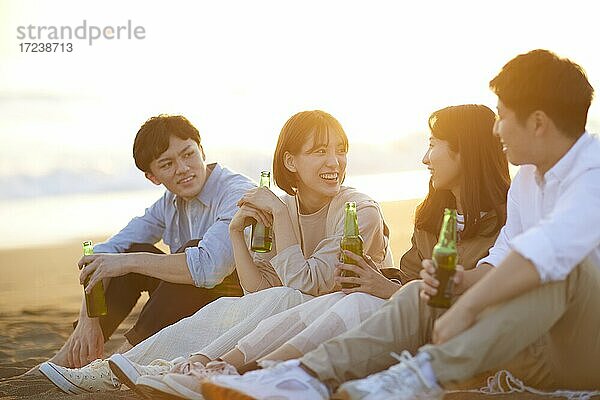 Junge japanische Freunde am Strand