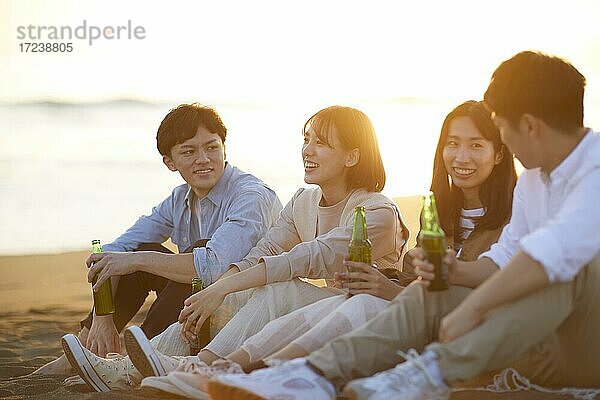 Junge japanische Freunde am Strand