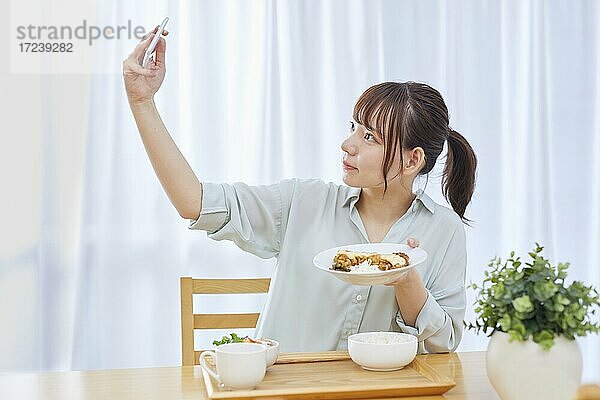 Junge Japanerin genießt das Essen zu Hause