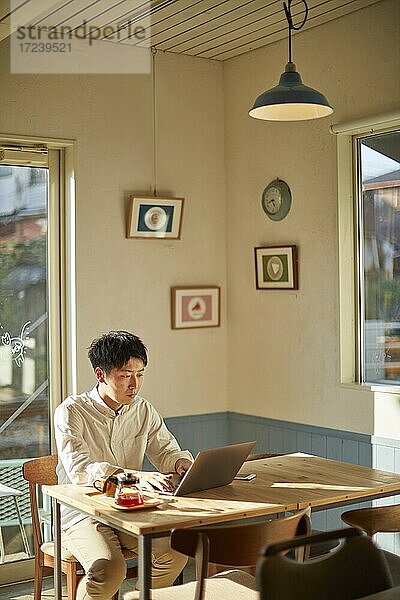 Junger japanischer Mann in einem Café