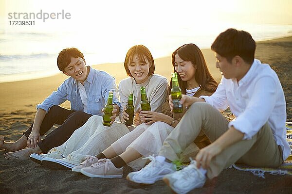 Junge japanische Freunde am Strand