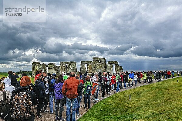 Touristen besuchen Stonehenge bei wolkenverhangenem Himmel  Wiltshire  England  Großbritannien  Europa