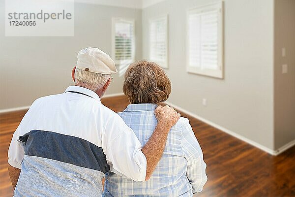 Älteres Paar vor leerem Zimmer im neuen Haus