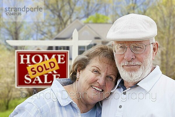 Glückliches zärtliches älteres Paar vor Schild Haus zu verkaufen  verkauft  Immobilien