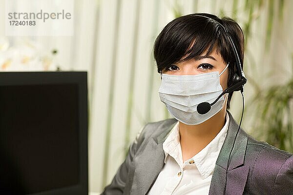 Frau im Büro Schreibtisch trägt medizinische Gesichtsmaske