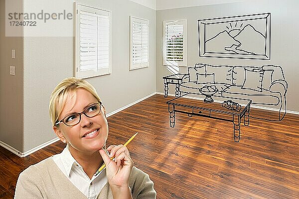 Frau mit Bleistift in leeren Raum des neuen Hauses mit Couch und Tisch Zeichnung an der Wand