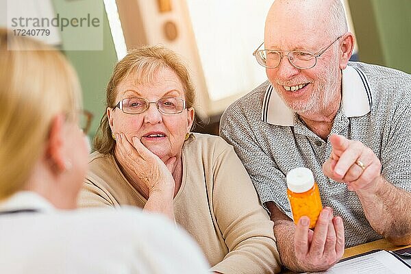 Arzt oder Krankenschwester  die einem älteren Ehepaar verschreibungspflichtige Medikamente erklären