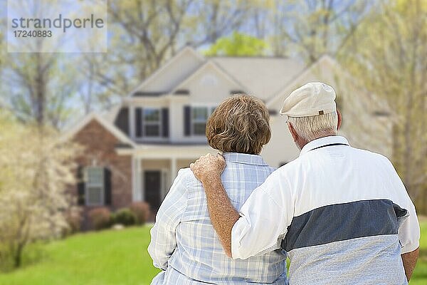 Glückliches Seniorenpaar von hinten mit Blick auf die Haus
