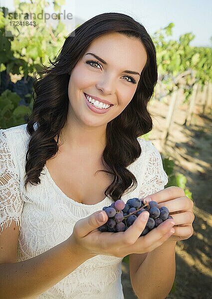 Junge erwachsene multiethnische Frau genießen die Weintrauben in den Weinberg außerhalb