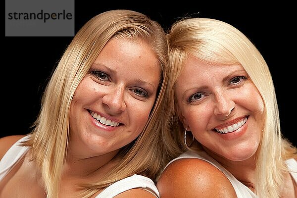 Zwei schöne lächelnde Schwestern Porträt vor einem schwarzen Hintergrund