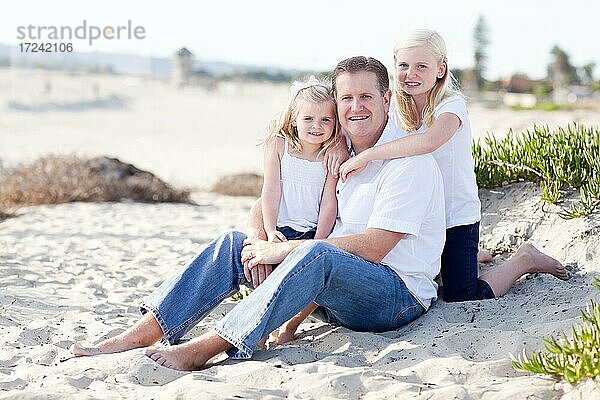 Gutaussehender Papa und seine niedlichen Töchter Porträt am Strand