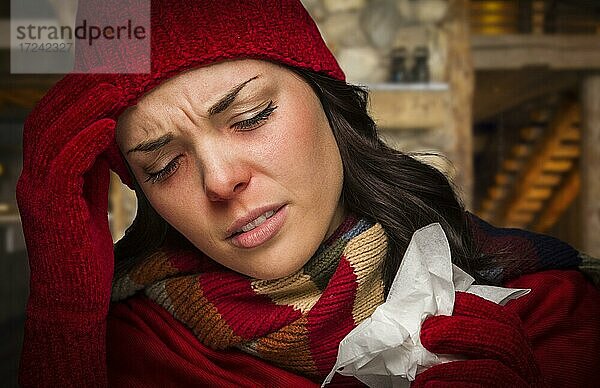 Warm angezogene kranke Frau in der Kabine mit Taschentuch