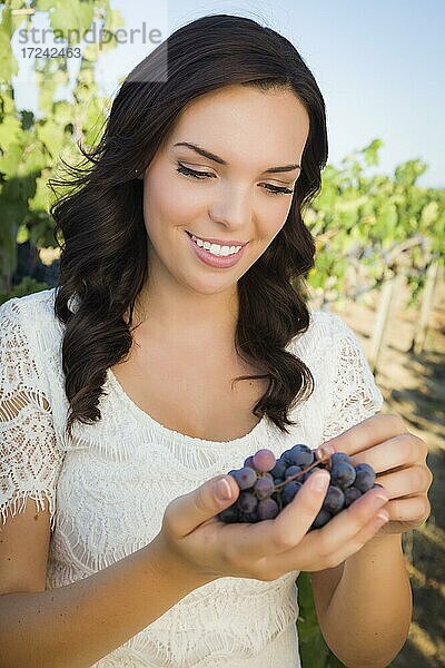 Junge erwachsene multiethnische Frau genießen die Weintrauben in den Weinberg außerhalb