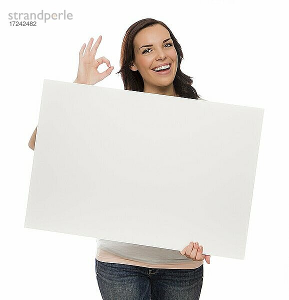 Schöne gemischtrassige Frau hält leeres Schild vor weißem Hintergrund gibt OK Geste