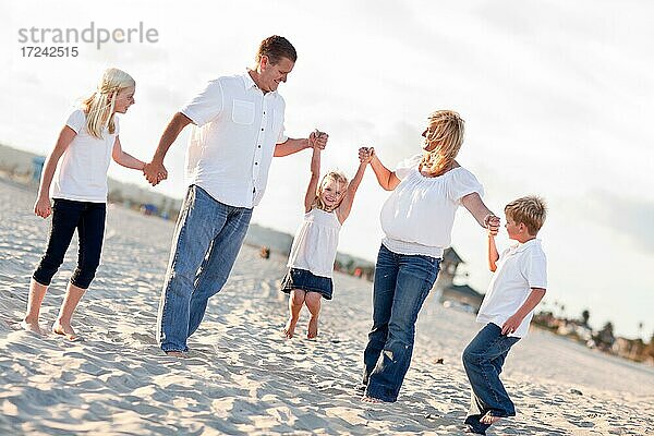 Adorable kleines Mädchen schwingt mit ihren Eltern und Familie am Strand