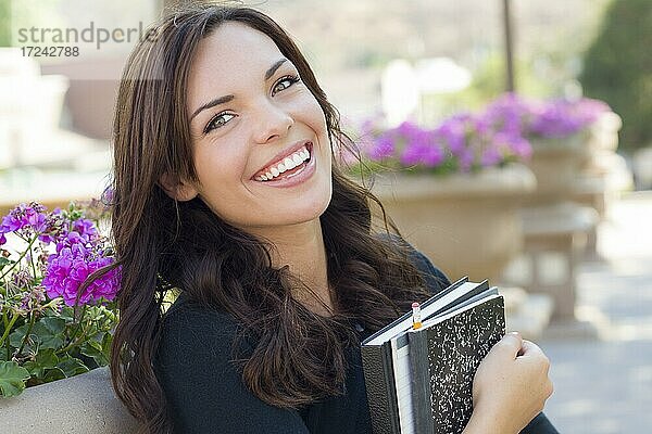 Porträt der hübschen jungen Studentin trägt Bücher auf dem Schulcampus