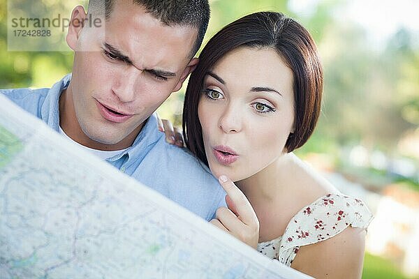 Glückliches gemischtrassiges Paar  mit Landkarte im Freien schaut