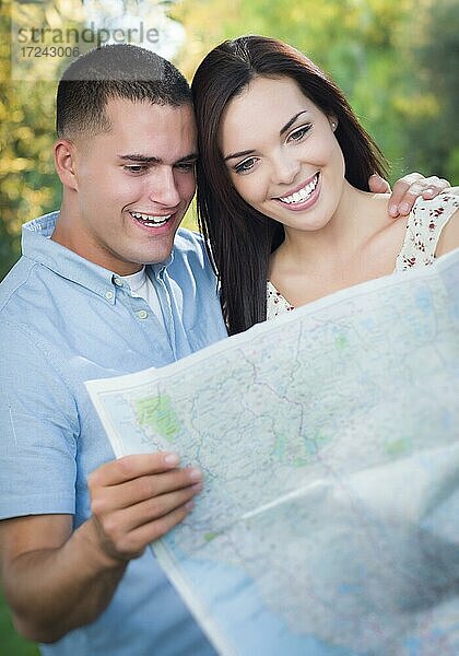Glückliches gemischtrassiges Paar  mit Landkarte im Freien