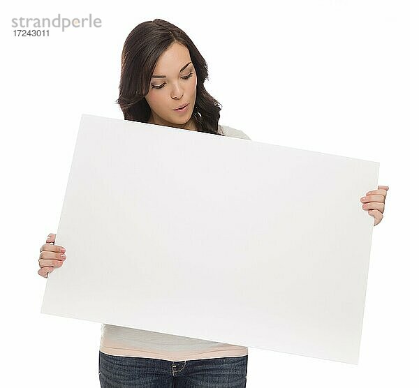 Schöne gemischtrassige Frau hält und schaut auf leeres Schild vor einem weißen Hintergrund