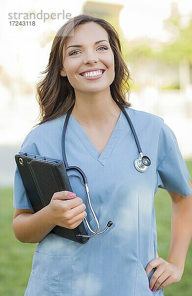 Porträt einer attraktiven jungen erwachsenen Frau  Ärztin oder Krankenschwester hält Touchpad außerhalb