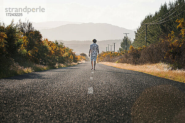 Neuseeland  Nordinsel  Rotorua  Rückansicht eines jungen Mannes auf der Straße in der Bay of Plenty