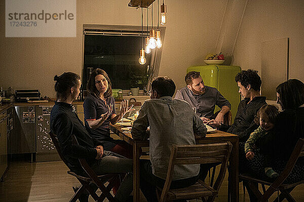 Männliche und weibliche Freunde unterhalten sich beim Abendessen zu Hause
