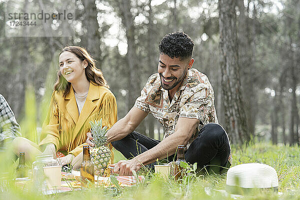 Männliche und weibliche Freunde genießen ein Picknick im Wald