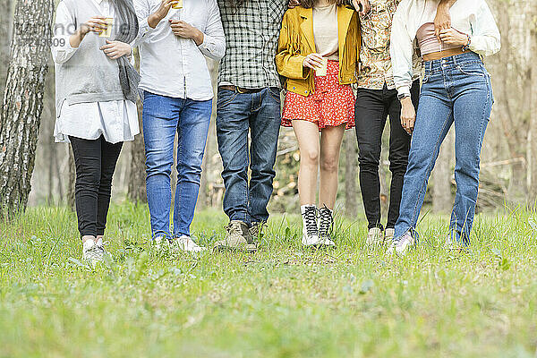 Männliche und weibliche Freunde gehen durch ein Feld im Wald