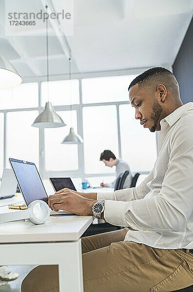 Männlicher Unternehmer mit Laptop im Büro
