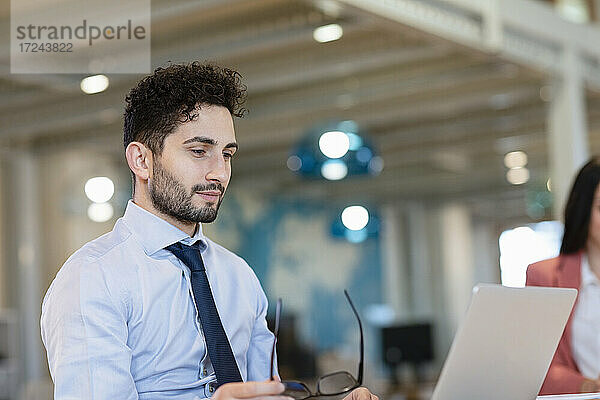 Männliche Fachkraft arbeitet an einem Laptop in einem Coworking-Büro