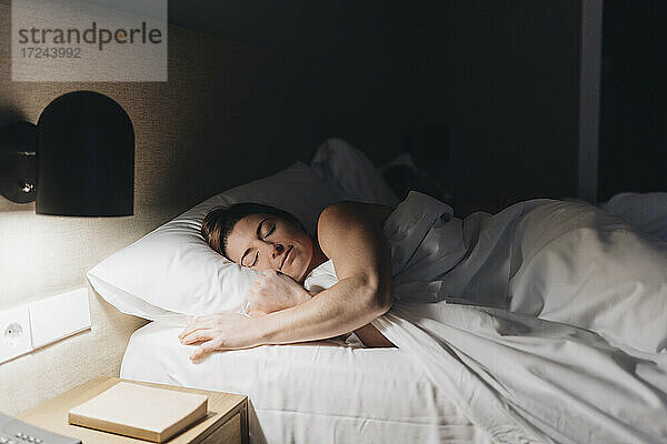 Schöne Frau schläft auf dem Bett im Hotelzimmer