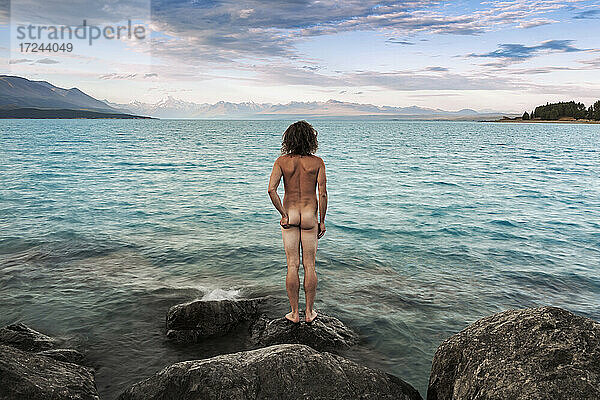 Neuseeland  Canterbury  Rückansicht eines nackten Mannes mit Blick auf den Lake Pukaki bei Sonnenuntergang