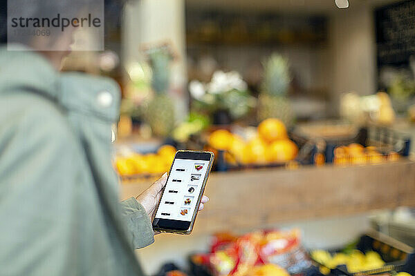 Frau kauft Lebensmittel über eine mobile Anwendung im Supermarkt
