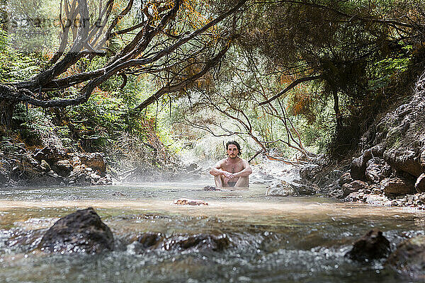 Mann ohne Hemd entspannt sich im Thermalfluss  Rotorura  Neuseeland