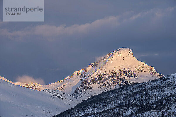 Norwegen  Tromso  Schneebedeckter Berggipfel im Licht des Sonnenaufgangs