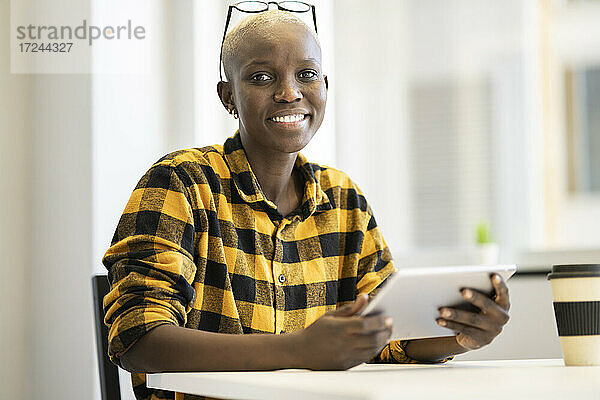 Lächelnde Geschäftsfrau hält digitales Tablet zu Hause