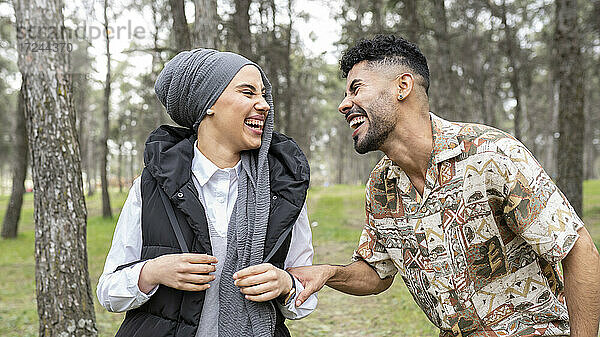 Junger Mann lachend mit Frau im Wald