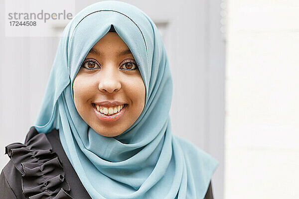 Lächelnde Frau mit braunen Augen  die einen Hidschab trägt