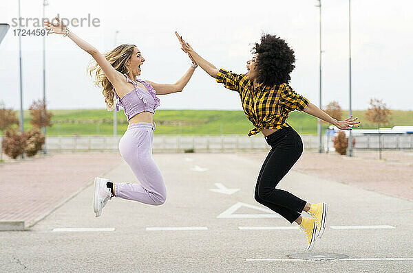Freundinnen springen auf der Straße im Freien