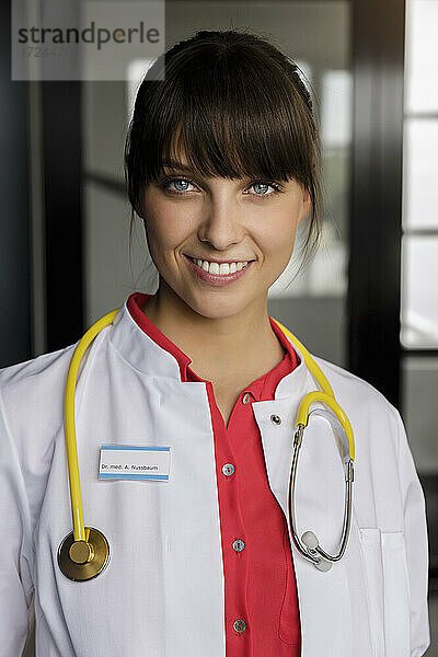 Lächelnde Ärztin mit Stethoskop in einem medizinischen Gebäude